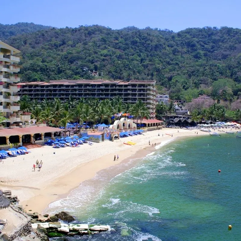 Secluded Puerto Vallarta beach with resorts and mountains in the background