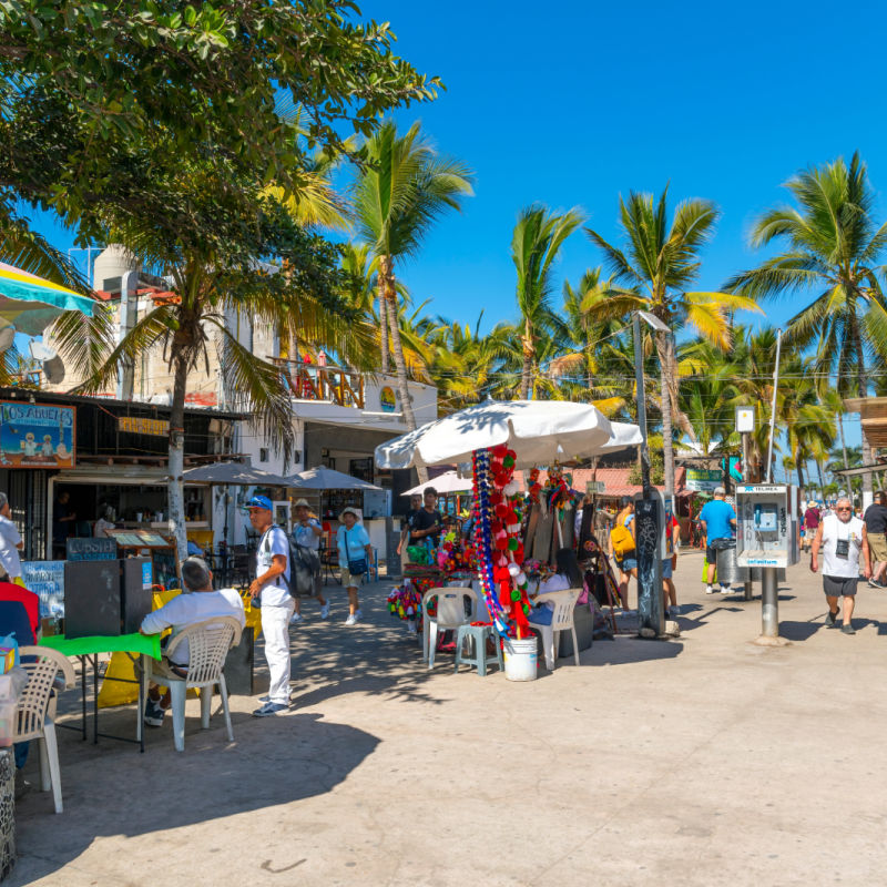 Colorful shops, cafes, hotels and souvenir booths line the seaside promenade boardwalk at Los Muertos Olas Altas beach in the touristic Romantic Zone in Puerto Vallarta