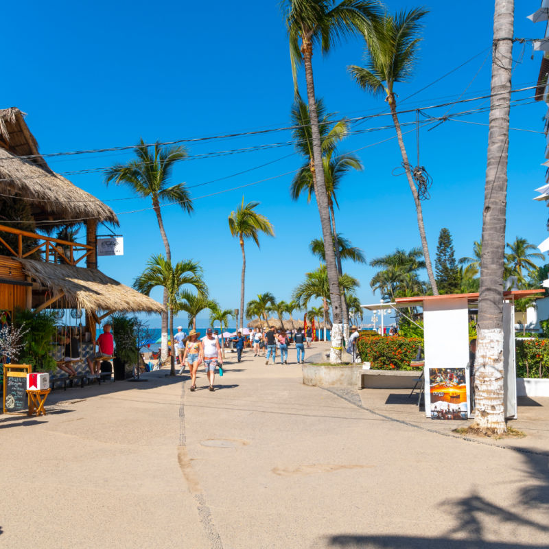 Colorful shops, cafes, hotels and souvenir booths line the seaside promenade boardwalk at Los Muertos Olas Altas beach in the touristic Romantic Zone