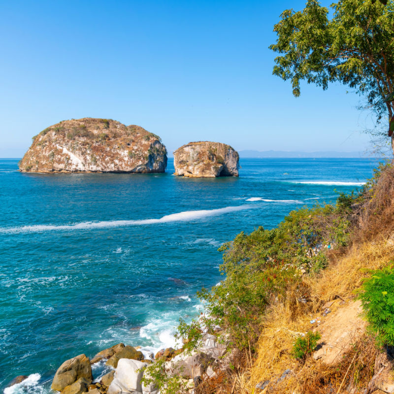 View from the coastline of the large boulder islands offshore near Banderas Bay at Los Arcos National Park along the Mexican Riviera at Puerto Vallarta, Mexico
